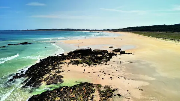 Altın kumları, berrak suları, yumuşak dalgaları ve güneşli bir gökyüzü olan sakin bir sahil.