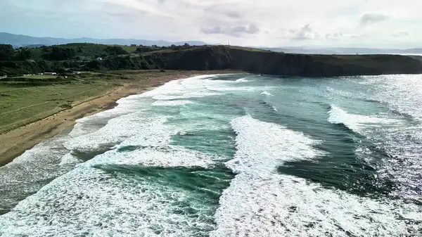 Güzel bir sahil şeridine çarpan dalgaların çarpıcı hava görüntüleri doğanın gücünü ve dinginliğini gözler önüne seriyor..