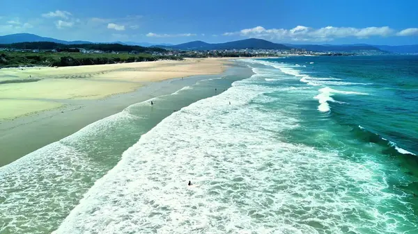 Güzel bir kumsalın nefes kesici bir görüntüsü, çarpıcı dalgalar, kum ve güzel bir sahil şeridi.