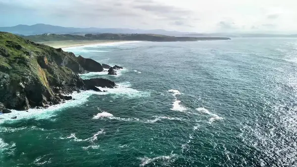 Muhteşem kayalıkları, dalgaları ve çarpıcı doğal güzelliği olan güzel bir kıyı manzarası keşfedin.