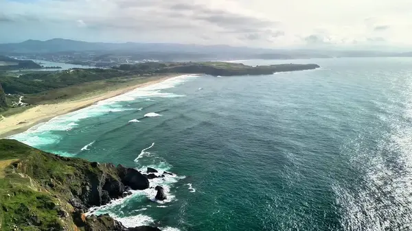 Nefes kesici hava manzarası yemyeşil ve çarpıcı okyanus dalgalarıyla nefes kesici sakin bir kıyı şeridi sergiliyor.