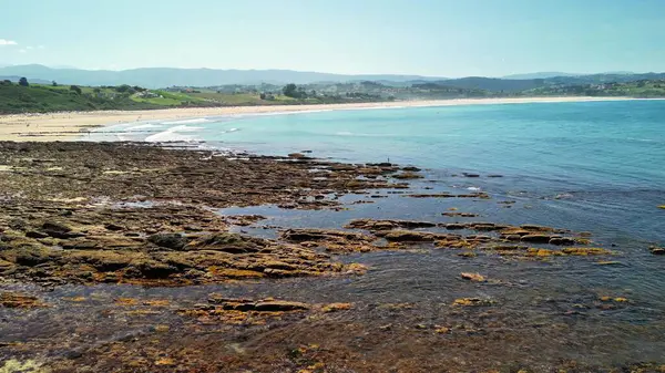 Kayalık bir kıyı şeridi ve el değmemiş berrak mavi suları içeren bu büyüleyici ve sakin kıyı manzarasını derinlemesine araştırın.