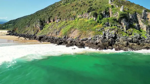 Nefes kesici bir kıyı manzarası çarpıcı yemyeşil tepeler, engebeli kayalık kıyılar ve berrak mavi sular.