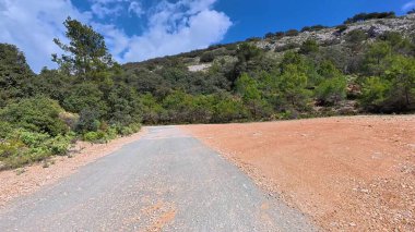 Parlak mavi bir gökyüzünün altında, sakin bir dağ manzarasında, bu çarpıcı çakıl yolunda bir yolculuğa çıkın.