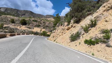 Güzel, dolambaçlı bir yol güzel bir şekilde sergiler çarpıcı manzaralar, canlı bir manzara, ve berrak, mavi gökyüzü