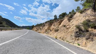 Güzel bir otoyol görkemli dağların arasından esiyor, güzellikler ve açık mavi gökyüzü.