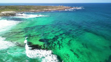 Nefes kesici hava manzaraları serin turkuaz suların şaşırtıcı derecede canlı sahil şeridine çarpan dalgaları gösteriyor.