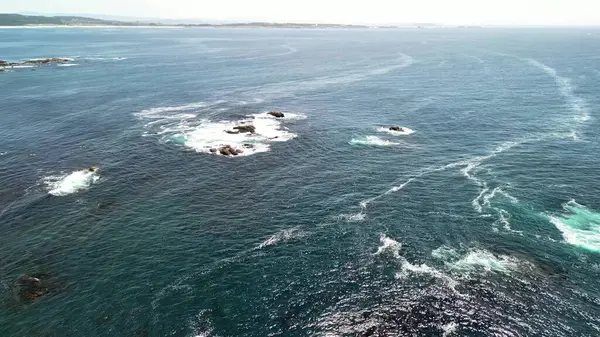 Büyüleyici ve çarpıcı hava görüntüleri canlı bir okyanusu, kayalık oluşumları ve dönen dalgaları gösteriyor.