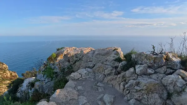 Göz kamaştırıcı, nefes kesici panoramik manzara görkemli kayalık uçurumlar ve parlak bir gökyüzünün altında sakin bir okyanus.
