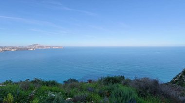 Etrafı yemyeşil yeşilliklerle çevrili güzel bir sahil uçurumundan nefes kesici bir okyanus manzarası.