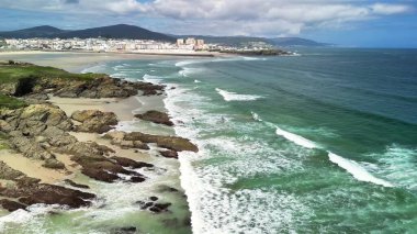 Dalgaların kayalara çarptığı güzel bir kıyı manzarası mükemmel bir sahne için uzak ufuk çizgisini güçlendiriyor.