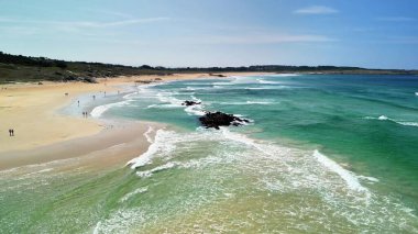 Canlı turkuaz sular ve altın kumun yer aldığı sakin sahili gösteren bu nefes kesici hava manzarasının tadını çıkarın.