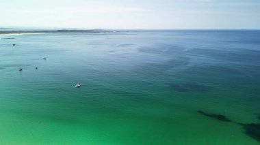 Göz kamaştırıcı hava görüntüleri mükemmel bir şekilde berrak gökyüzünün altında canlı turkuaz okyanus dalgalarını yakalıyor.
