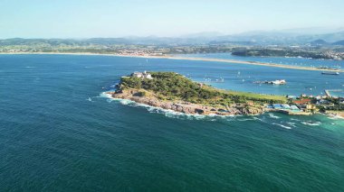 Sersemletici hava görüntüleri, sakin mavi denizler ve huzurlu marinalarla çevrili yemyeşil bir ada gösteriyor.