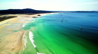 Kendinizi keşfedin ve sahildeki büyüleyici zümrüt yeşili kumsalın nefes kesici güzelliğine daldırın.
