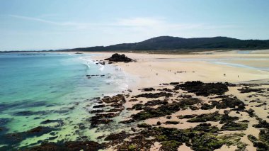 Kristal berrak suları, yumuşak kumları ve çevresini çevreleyen güzel manzaralarıyla nefes kesici bir sahil manzarasının tadını çıkar.