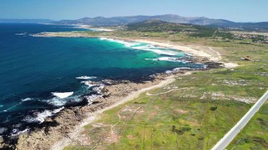 Bereketli yeşil çevreyle birlikte kristal berrak turkuaz suları barındıran nefes kesici kıyı manzarası.