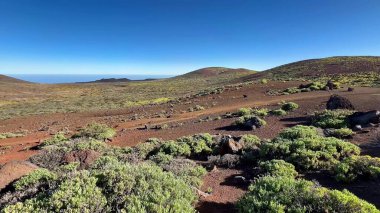 Nefes kesici volkanik bir manzaranın nefes kesici görüntüsü canlı yeşillik ve çarpıcı derecede açık mavi gökyüzünü yansıtıyor.