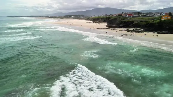 Hava manzarası, berrak mavi suları ve altın plajları olan sakin bir kıyı şeridini gösteriyor. Rahatlamak için ideal.