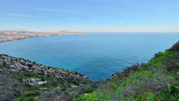 Sakin ve kristal mavi sular üzerinde çarpıcı panoramik görüntülere yol açan nefes kesici bir kıyı yolu.