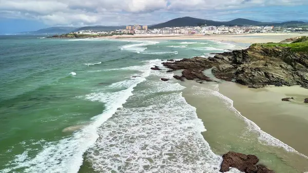 Bereketli yeşilliklerle çevrili kayalık kıyılara vuran yumuşak dalgalarla nefes kesici sahil manzarasını deneyin.