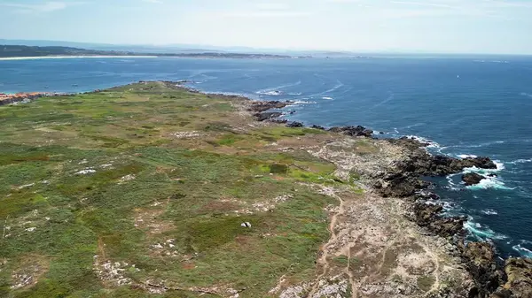 Göz kamaştırıcı hava manzarası kayalık kıyıları, canlı yeşillikleri ve ötesinde okyanusla nefes kesici bir kıyı şeridi sergiliyor.