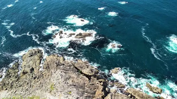 Hava görüntüleri dalgaları güzel bir şekilde yakalar. Titreyen mavi okyanusun baş döndürücü kayalık kıyılarına yorulmadan çarpar.