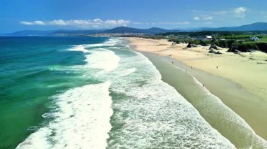 Nefes kesici bir sahil manzarası. Nazik dalgalar süzülüyor. Çok güzel bir sahil şeridi.