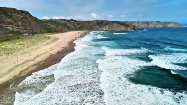 Dalgaların sahile ve kayalıklara çarptığı çarpıcı bir sahil manzarasının nefes kesici güzelliğine dalmak.