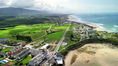 Bu çarpıcı hava manzarası güzel bir şekilde okyanus kıyılarıyla buluşan yemyeşil tarlaları gösteriyor.