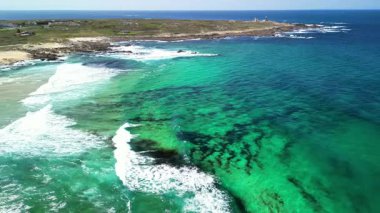 Nefes kesici hava manzaraları serin turkuaz suların şaşırtıcı derecede canlı sahil şeridine çarpan dalgaları gösteriyor.
