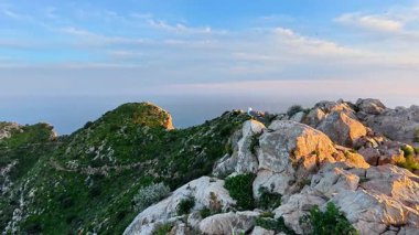 Göz kamaştırıcı bir kıyı manzarası engebeli kayalık çıkıntılar ve yemyeşil bitki örtüsü.