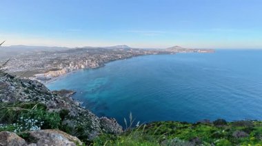 Karşınızda canlı bir kıyı şehrini ve kayalık bir yamacın tepesinden gelen sakin turkuaz suları gösteren çarpıcı bir manzara.