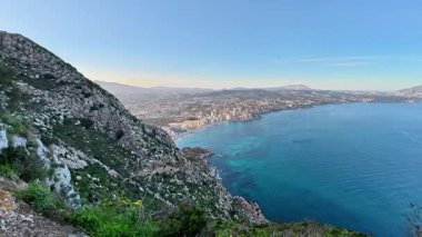 Uçurumlar, engin okyanuslar ve canlı yeşillikler güzel bir şekilde sergilenen nefes kesici bir kıyı manzarası.