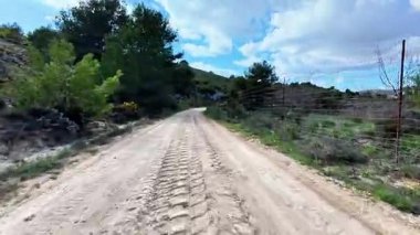 Çok güzel bir manzara sergiliyor huzurlu toprak bir yol zarif bir şekilde renkli yapraklar ve büyük tepeler arasında.