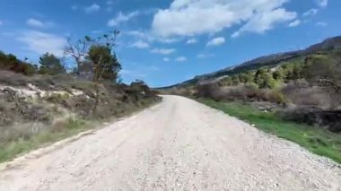 Bereketli yeşil ve mavi gökyüzünde dolambaçlı sakin bir çakıl yolu, açık hava maceraları için mükemmel..