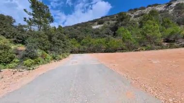 Parlak mavi bir gökyüzünün altında, sakin bir dağ manzarasında, bu çarpıcı çakıl yolunda bir yolculuğa çıkın.