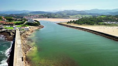 Resimli bir İspanyol manzarasında, kumlu bir plaja uzanan nehir yatağının nefes kesici hava manzarası..