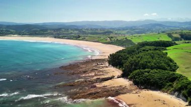 Havadan bakıldığında yemyeşil ve engebeli kayalarla çevrili sakin bir sahil görünüyor. Resimli bir manzara yaratıyor.