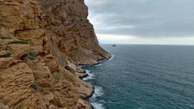 Bir dağ ve deniz olan güzel bir manzara.