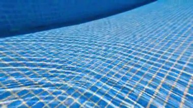 Canlı bir su altı görüntüsü mavi bir havuz yüzeyi sergiliyor. Şebeke desenli, yaz temaları için mükemmel..