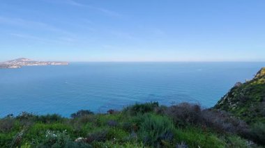 Etrafı yemyeşil yeşilliklerle çevrili güzel bir sahil uçurumundan nefes kesici bir okyanus manzarası.