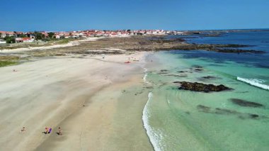 Havadan bakıldığında, el değmemiş bir kumsal, hafif dalgalar ve hareketli bir kasaba görünüyor. Eğlenceli yaz kaçışları için mükemmel.