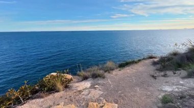 Huzurlu suları ve çarpıcı bir günbatımını gösteren nefes kesici bir sahil manzarası huzur hissi uyandırıyor.