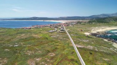 Kesinlikle nefes kesici bir hava görüntüsü, yemyeşil bir manzara, sakin bir plaj ve güzel bir kasaba sergiliyor.