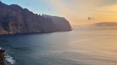 Okyanus kıyısında gün batımında kayalıkların nefes kesici ve çarpıcı güzelliğini deneyimleyin. Unutulmaz bir manzara.