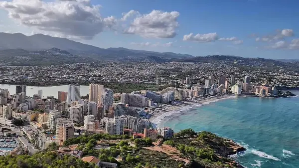 Nefes kesen hava manzarası canlı bir kıyı şehrini güzel plajları ve yuvarlanan dağlarıyla gösteriyor.