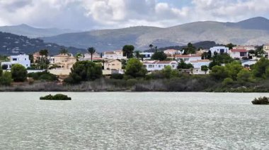 Burası görkemli dağlara karşı yapılmış lüks evlerin sergilendiği göz kamaştırıcı ve görkemli bir göl manzarası.