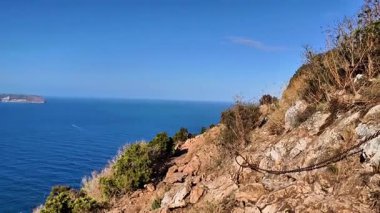 Kayalık ve engebeli kıyı şeridinin çarpıcı manzarası berrak suları ve güzel, parlak mavi gökyüzünü barındırır.
