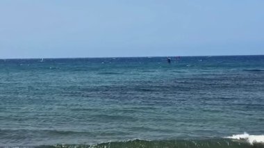 Nefes kesen bir okyanus manzarası sahile vuran nazik dalgalar ve güzel, berrak mavi bir gökyüzü.